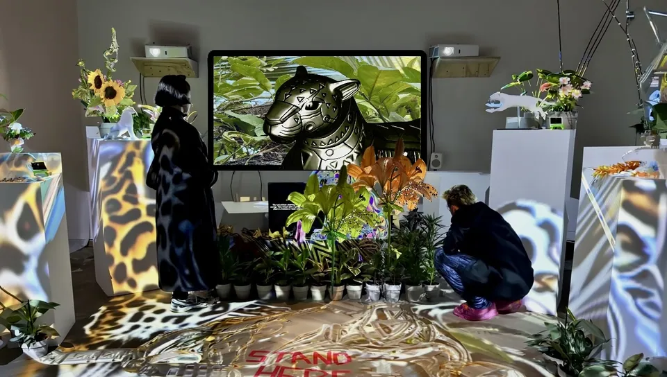 A jaguar on a screen, among flowers and projected jaguar patterns.